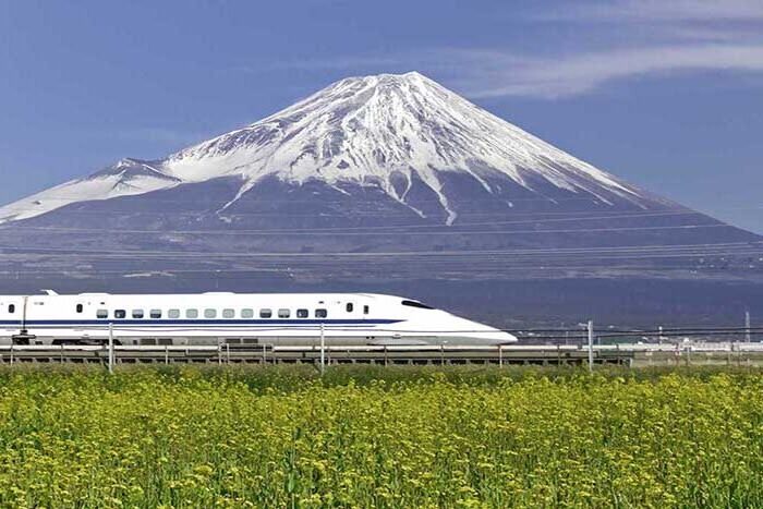 A bullet train in Japan passing by Mount Fuji.